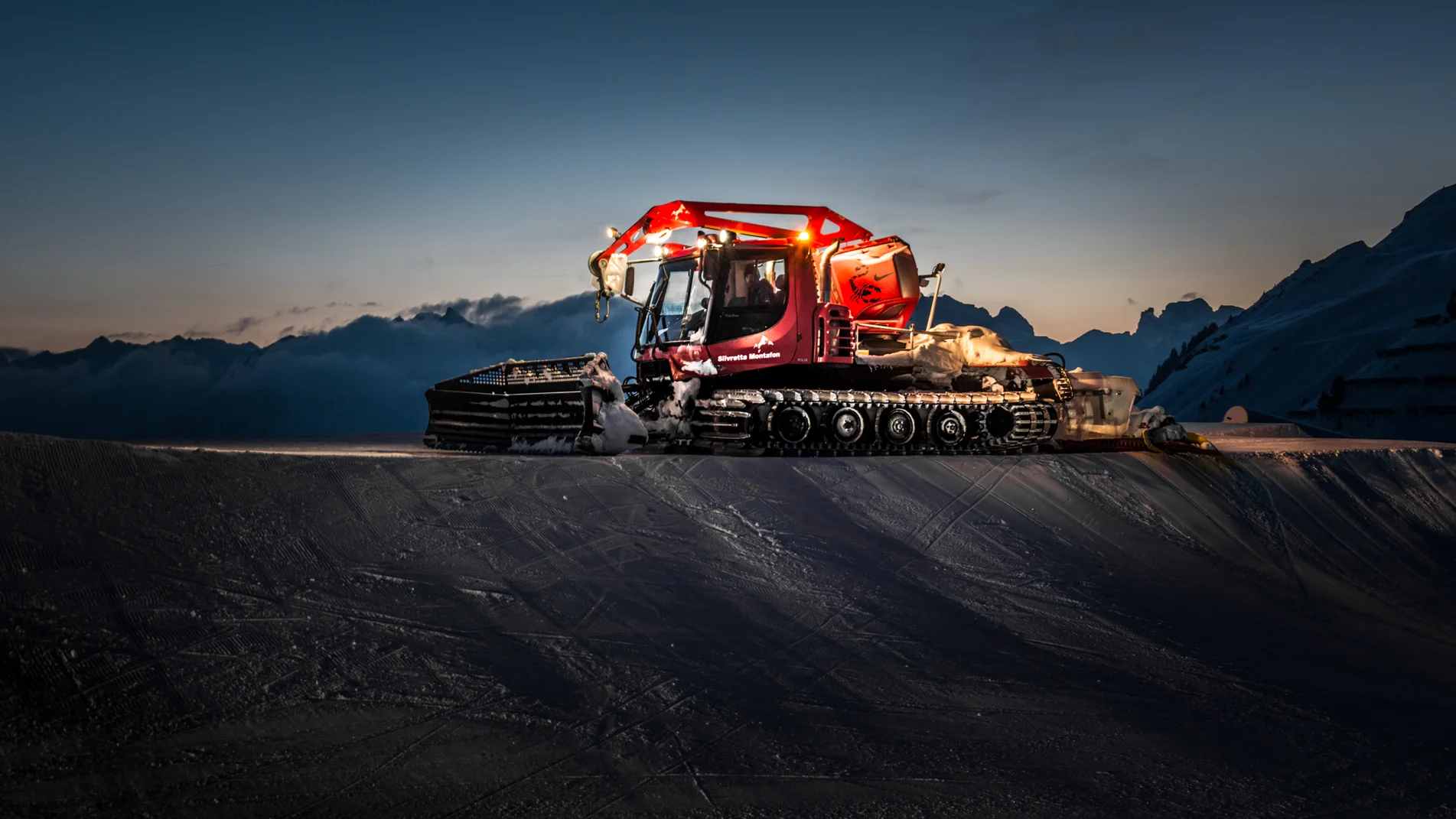 Ein roter Pistenbully in einer Abendszenerie in der Silvretta Montafon  | © Silvretta Montafon 