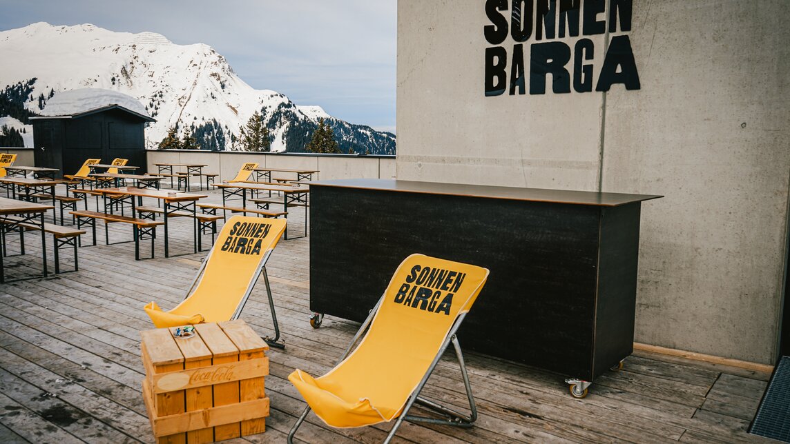 Sonnen Barga - Silvretta Montafon | © Silvretta Montafon - Vanessa Strauch Der Eingang zur Sonnenbarga mit gelben Liegestühlen und Bierbänken auf der Terrasse. | © Silvretta Montafon - Vanessa Strauch