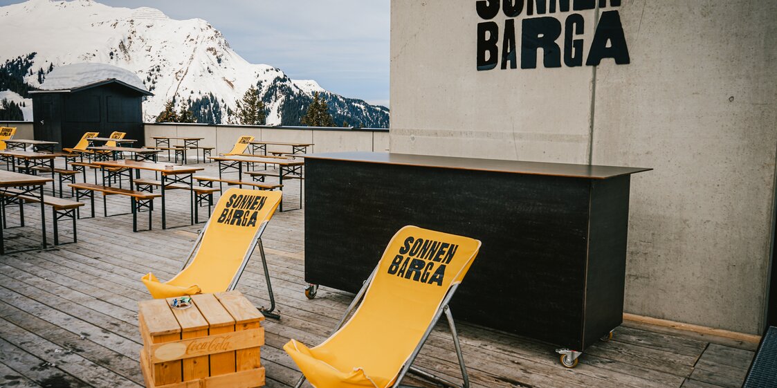 Sonnen Barga - Silvretta Montafon | © Silvretta Montafon - Vanessa Strauch Der Eingang zur Sonnenbarga mit gelben Liegestühlen und Bierbänken auf der Terrasse. | © Silvretta Montafon - Vanessa Strauch