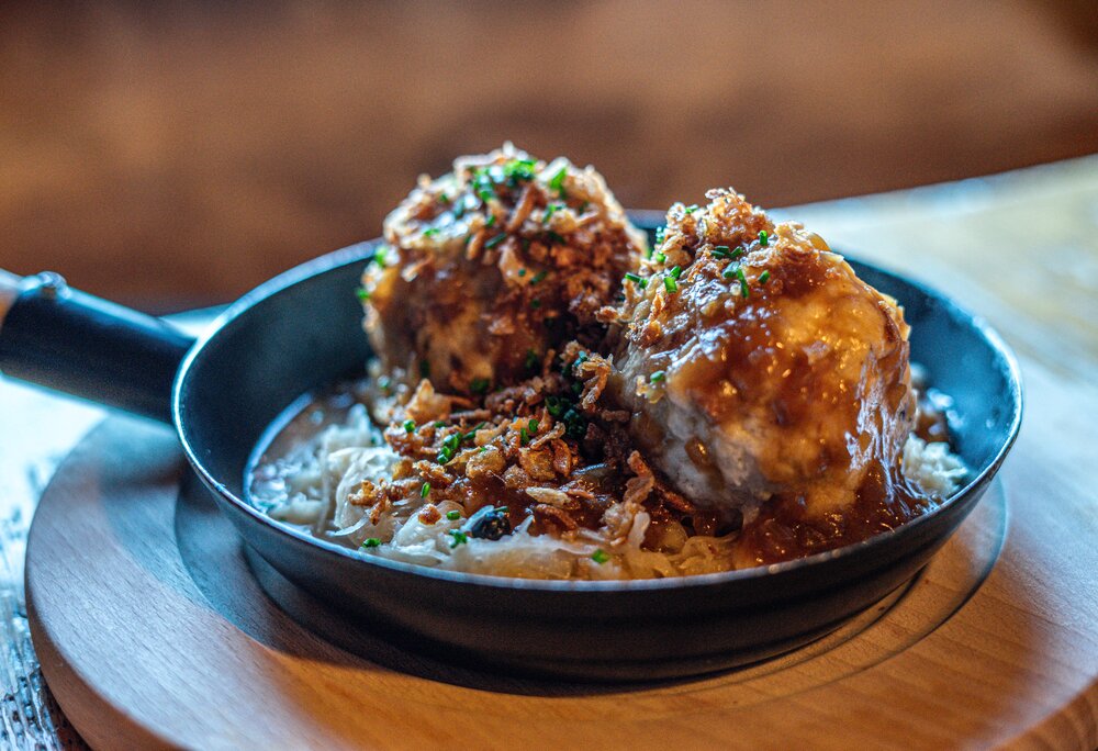 Semmelknödel & Kraut - Silvretta Montafon | © Silvretta Montafon - Vanessa Strauch Eine Pfanne mit zwei Semmelknödeln und Sauerkraut im Valisera Hüsli in der Silvretta Montafon. | © Silvretta Montafon - Vanessa Strauch