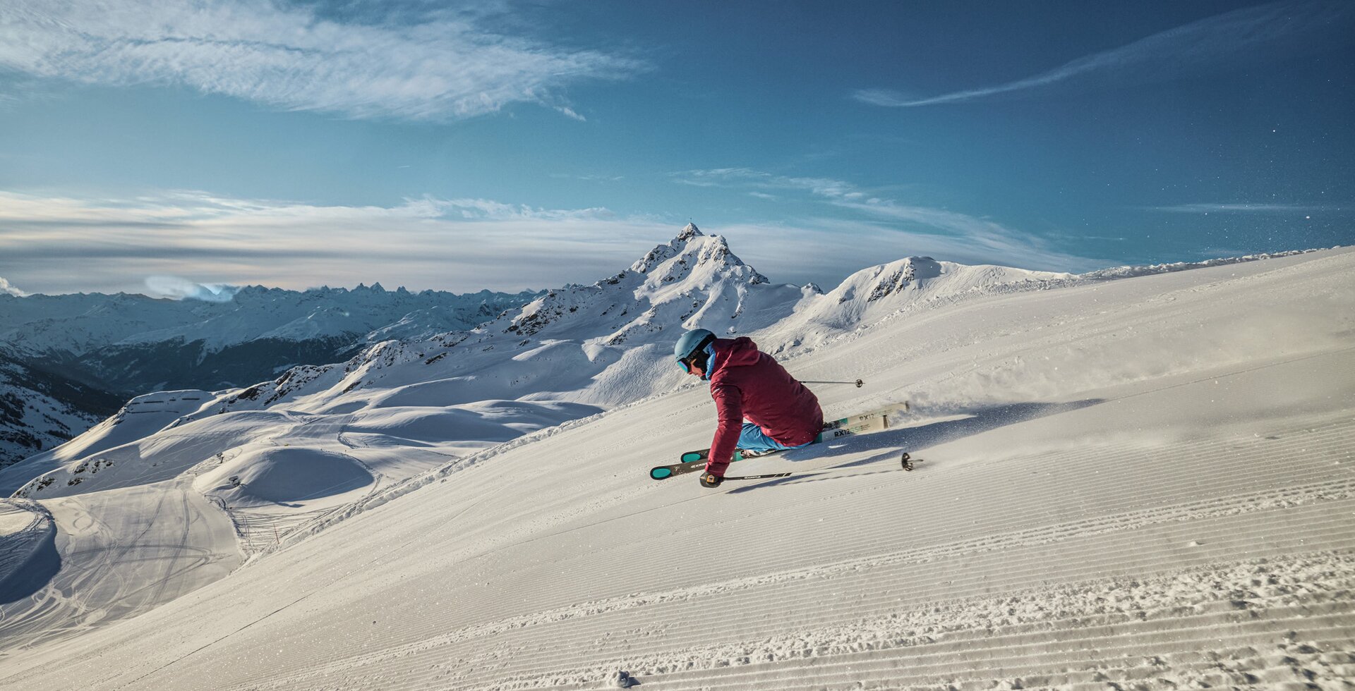 Ein Skifahrer fährt am Morgen über die frisch präparierte Piste mit der Zamangspitze im Hintergrund. | © Silvretta Montafon - Stefan Kothner