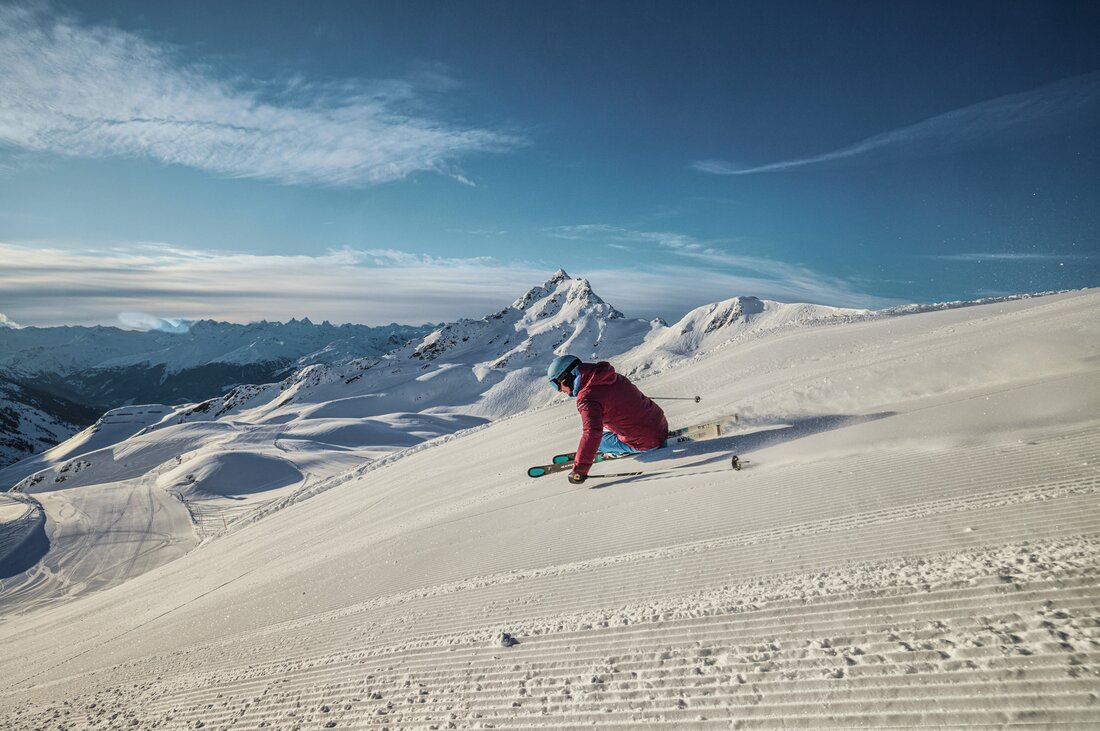Skifahrer am Hochjoch - Silvretta Montafon | © Silvretta Montafon - Stefan Kothner Ein Skifahrer fährt am Morgen über die frisch präparierte Piste mit der Zamangspitze im Hintergrund. | © Silvretta Montafon - Stefan Kothner