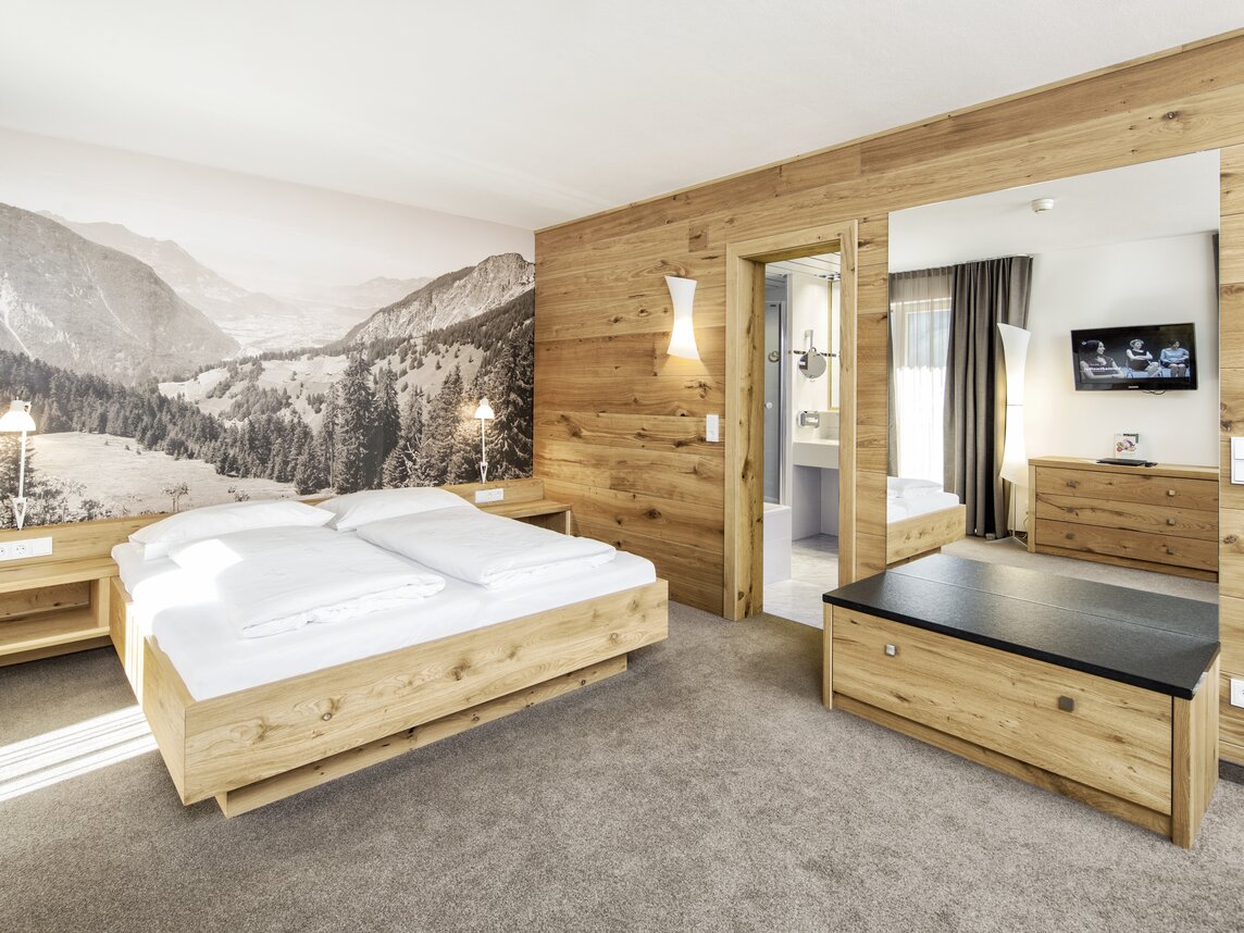 Junior Suite - Silvretta Montafon | © Silvretta Montafon - Markus Gmeiner Gemütliches Doppelbett mit anliegendem Badezimmer | © Silvretta Montafon - Markus Gmeiner